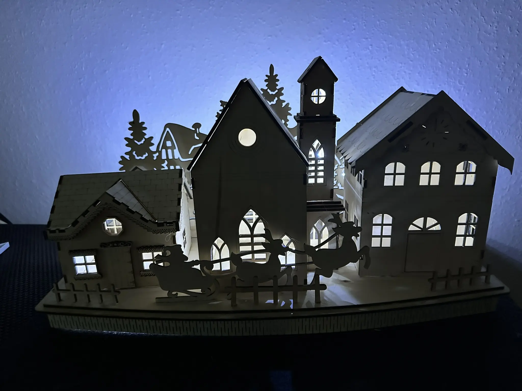 Schlittenfahrt im Weihnachtsdorf – Häuser und Schlitten im Vordergrund