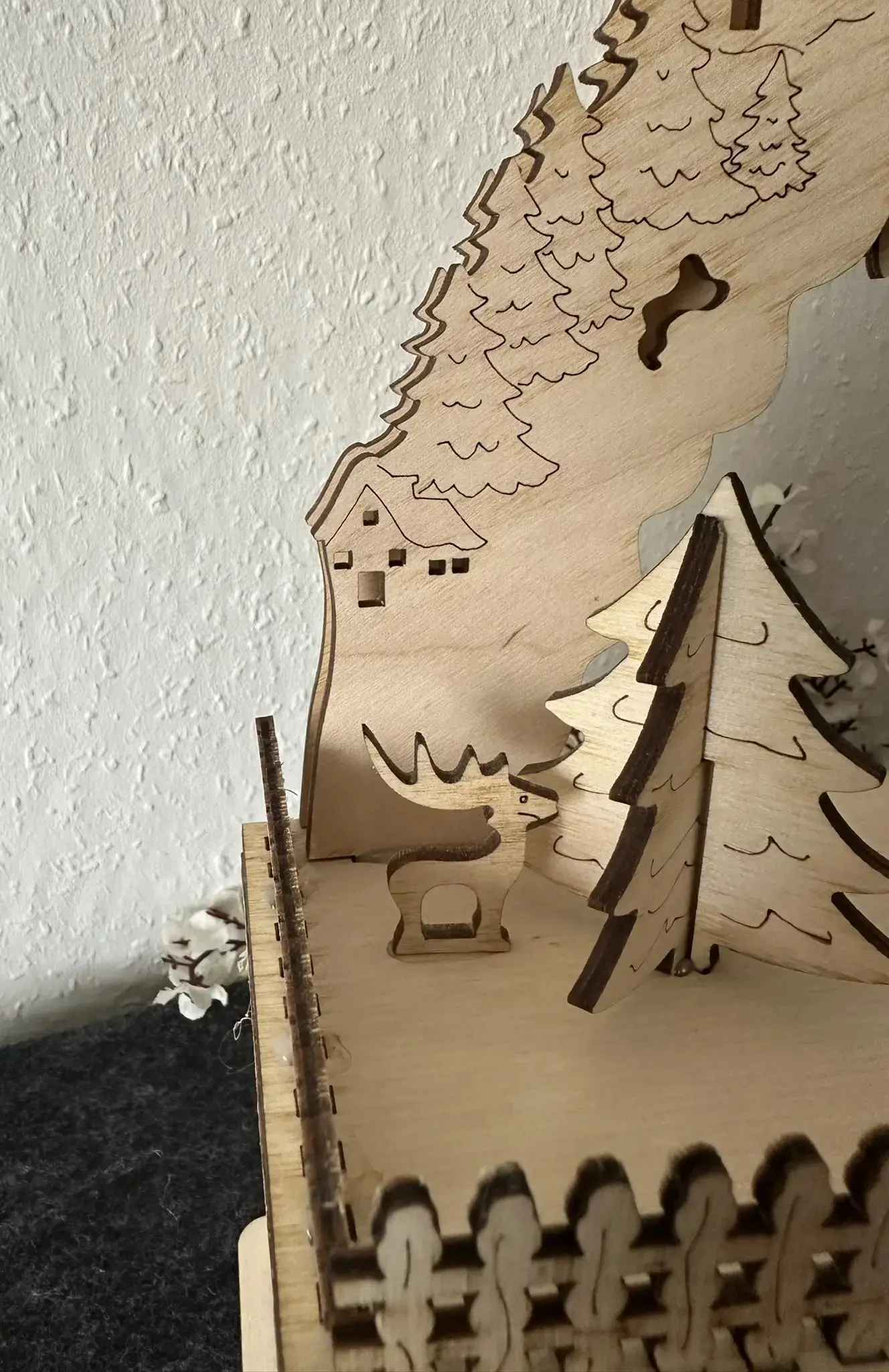 Detailansicht Schwibbogen Weihnachtsdorf, Elchfigur und Bäume in Holzarbeit